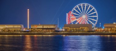 Al Maha Adası 'ndaki Lusail Kış Harikalar Diyarı eğlence parkı. Lusail şehri, Katar. Dönme dolabı gösteren uzun pozlu gece çekimi..