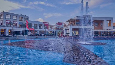 Kahire, Mısır - 28 Aralık 2023: Kahire festivali alışveriş merkezi yemek salonu gündüz manzarası fıskiyeleri, restoranlar, kahve dükkanları, arka planda insanlar ve bulutlar görünüyor