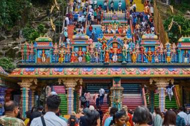 Batu Mağaraları 'nın girişi Hindu tanrılarının heykelleriyle süslenmiş ve yürüyen ziyaretçiler var. Gombak, Selangor Malezya.