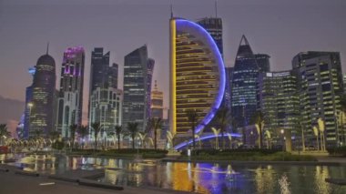 Doha Skyline batı körfezi bölgesinde, Doha, Katar gece görüntüsü. Otel parkından ön planda yapay göl ile çekilmiş. 