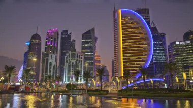 Batı körfezi yakınlarındaki Doha Skyline Otelin parkından ön planda yapay göl ile çekilmiş. Doha, Katar 