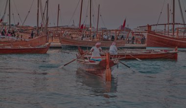 Katara14. Katar geleneksel dhow festivali Doha Katar Güneş Şutu Katılımcı ülkelerin bayrakları ve siluetleri ile Arap Körfezi 'nde geleneksel dhowları gösteriyor