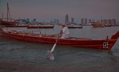 Katara14. Katar geleneksel dhow festivali Doha Katar Güneş Şutu Katılımcı ülkelerin bayrakları ve siluetleri ile Arap Körfezi 'nde geleneksel dhowları gösteriyor