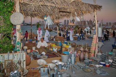 Katara 14th traditional dhow festival in Doha Qatar sunset shot showing shops with Traditional antique , handmade crafts with visitors walking clipart