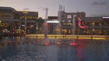 Kahire, Mısır - 28 Aralık 2023: Kahire festivali alışveriş merkezi yemek salonu gece manzarası fıskiyeleri, restoranlar, kahve dükkanları, arka planda insanlar ve bulutlar görünüyor