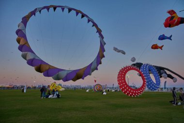 Qatar Kite Festivali 2025 Eski Doha Limanı 'nda (Mina Bölgesi) gün batımı çekimleri Doha ufkunda süzülen renkli uçurtmaların muhteşem gösterisini gösteriyor.