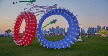 Qatar Kite Festivali 2025 Eski Doha Limanı 'nda (Mina Bölgesi) gün batımı çekimleri Doha ufkunda süzülen renkli uçurtmaların muhteşem gösterisini gösteriyor.