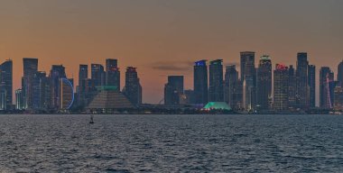 Doha, Katar-21 Mart 2025: Doha Katar alacakaranlıkta Corniche caddesinden ufuk çizgisi ve Arap körfezinde eşarplar