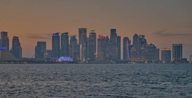 Doha, Katar-21 Mart 2025: Doha Katar alacakaranlıkta Corniche caddesinden ufuk çizgisi ve Arap körfezinde eşarplar