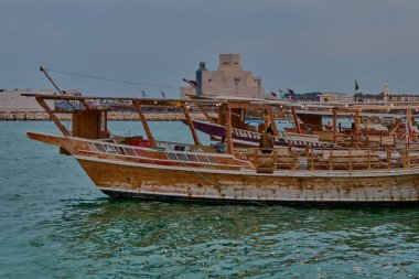 Doha, Katar-22 Nisan 2025: İslam Sanatları Müzesi gündüz görüşü Dow ile Arap körfezi, Katar bayrağı ön planda