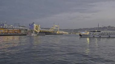 İstanbul, Türkiye - 9 Nisan 2025: İstanbul 'un Eminn çeyreği, Türkiye Yeni Cami ve Galata Köprüsü' nü gösteren feribottan gün batımı.