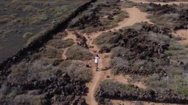 Drone pilot flying drone filming shooting video or taking photos on travel vacation in beautiful nature landscape on Lanzarote. High quality FullHD footage