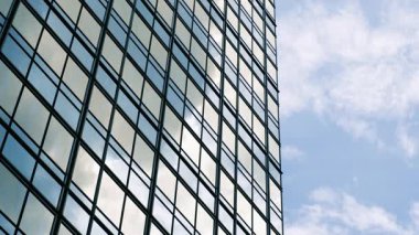 Soyut modern iş mimarisi. Camdan ve çelikten yapılmış duvarlar binaların yansımaları ve mavi gökyüzü.