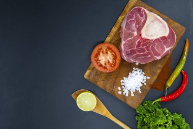 Taze çiğ biftekler ızgara için hazır, yukarıdan çekilmiş. Mevsimler, sebzeler, meyveler ve otlar.