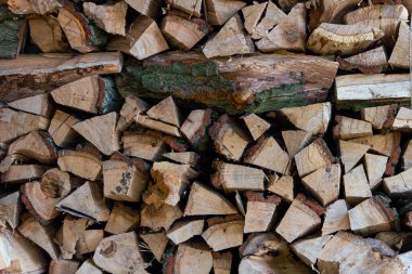 Odun istiflemenin arka planı. Bir odun yığını kış için hazır. Tahta kütükler, yakacak odun yığını..