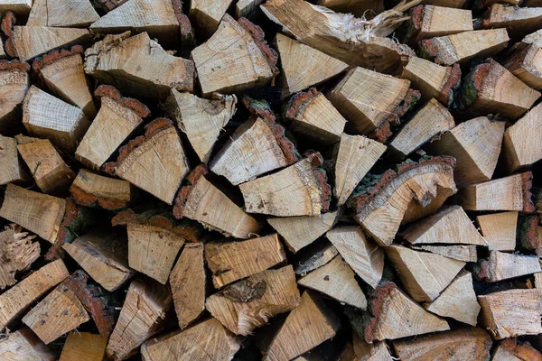 Odun istiflemenin arka planı. Bir odun yığını kış için hazır. Tahta kütükler, yakacak odun yığını..