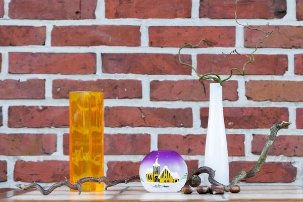 Masanın üzerinde duran tuğla bir duvarın arka planında duran şişe ve vazolar. Eski ve eski.