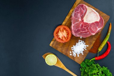 Taze çiğ biftekler ızgara için hazır, yukarıdan çekilmiş. Mevsimler, sebzeler, meyveler ve otlar.