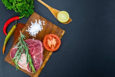 Taze çiğ biftekler ızgara için hazır, yukarıdan çekilmiş. Mevsimler, sebzeler, meyveler ve otlar.