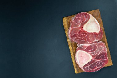 Taze çiğ biftekler ızgara için hazır, yukarıdan çekilmiş. Mevsimler, sebzeler, meyveler ve otlar.