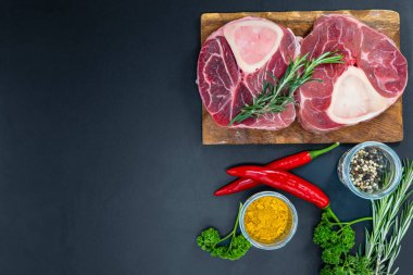 Taze çiğ biftekler ızgara için hazır, yukarıdan çekilmiş. Mevsimler, sebzeler, meyveler ve otlar.