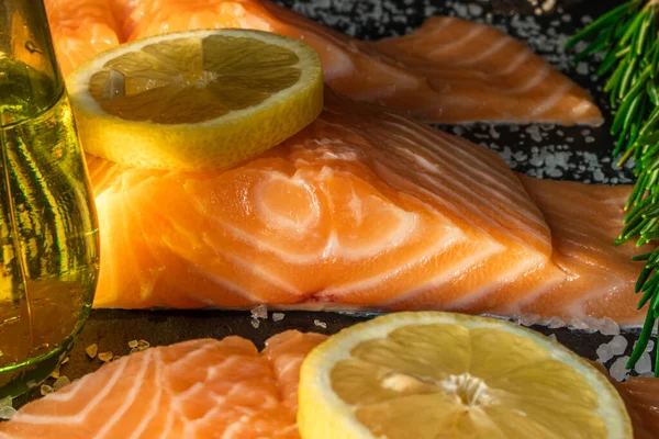 Koyu taştan bir arka planda baharatlı taze somon balığı bifteği. Tuz, baharat, baharat ve diğer malzemeler..