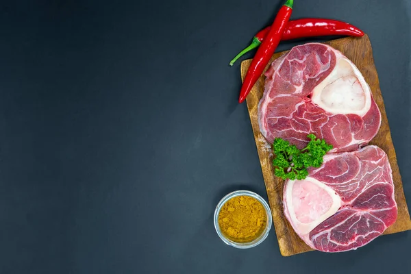 Taze çiğ biftekler ızgara için hazır, yukarıdan çekilmiş. Mevsimler, sebzeler, meyveler ve otlar.