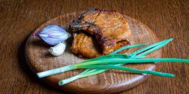 Grilled pork steak on a cutting board. View from above.