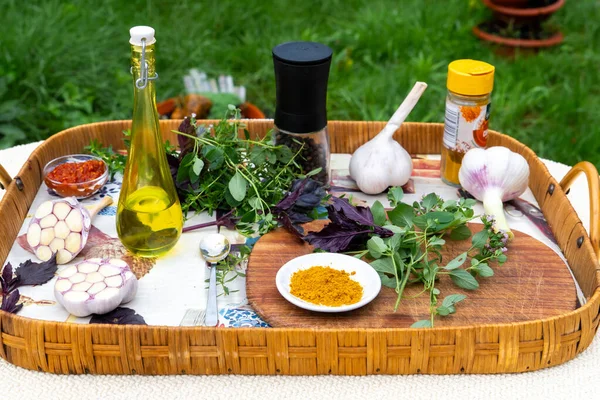 Baharatlı tepsi, sarımsak ve baharatlar bahçede bir masada..