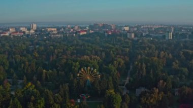 Lutsk Parkı 'nda dönme dolap. Ukrayna 'nın Lutsk kentindeki bir parkta sisli bir sabahın insansız hava aracı görüntüsü.
