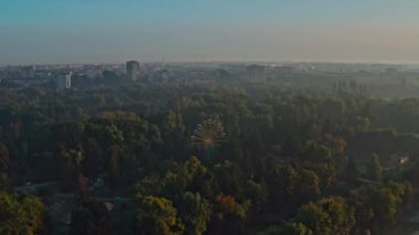 Lutsk Parkı 'nda dönme dolap. Ukrayna 'nın Lutsk kentindeki bir parkta sisli bir sabahın insansız hava aracı görüntüsü.