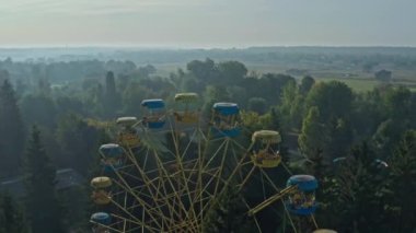 Lutsk Parkı 'nda dönme dolap. Ukrayna 'nın Lutsk kentindeki bir parkta sisli bir sabahın insansız hava aracı görüntüsü.