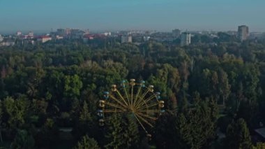 Lutsk Parkı 'nda dönme dolap. Ukrayna 'nın Lutsk kentindeki bir parkta sisli bir sabahın insansız hava aracı görüntüsü.