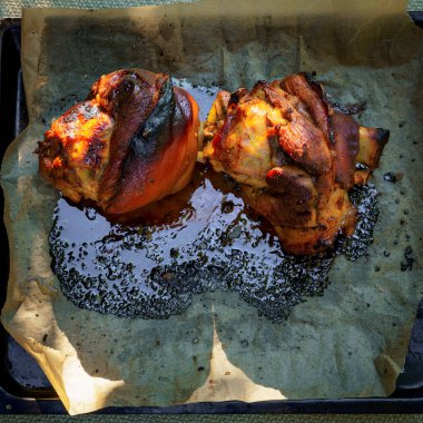 Parşömen kağıdında fırında pişirilmiş domuz budu. Doğada büyük miktarda yiyecek var. Yakın plan..