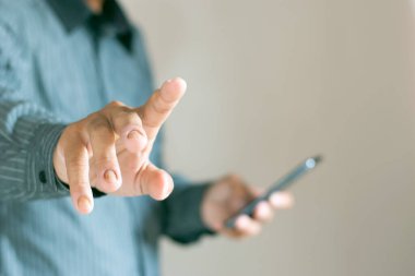 Close up footage shows a man using a smartphone and pointing it towards a business philosophy. clipart
