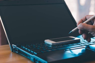 Bir kalem tut, not al ve telefonunu kullan. Defteri ofis masasının üzerine koy..