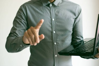 Erkek el bilgisayarı çalışıyor ve iş konseptini işaret ediyor.