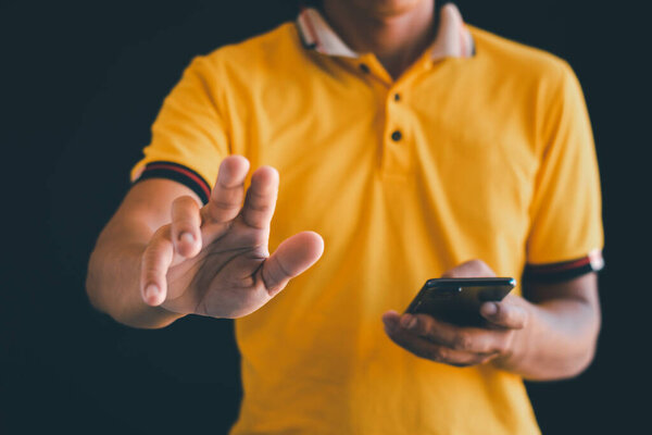Close-up photo of a man holding hands and reaching out with a mobile phone.