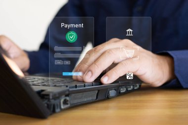 Adam bilgisayar ekranındaki alışveriş ikonunu gösterdi ve alışveriş arabası çeşitli eşyalarla doluydu..