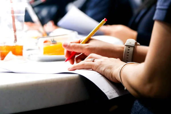机の上のノートに女性の手の書き込みのクローズアップショット 大学の教室で — ストック写真