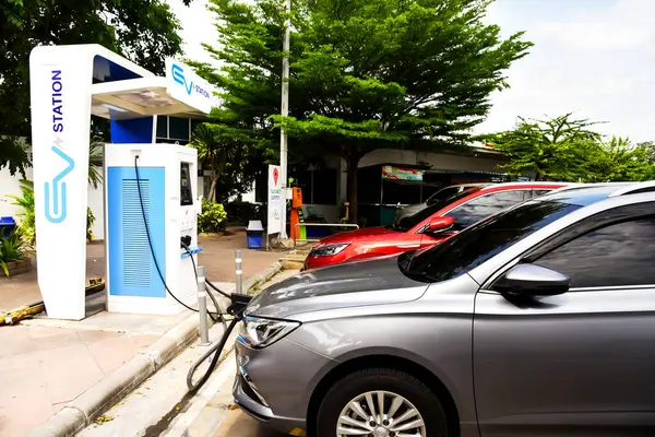 12 Ağustos 2023, Phetchaburi, Tayland Modern elektrikli araba istasyonda şarj ediliyor. Gelecekteki arabanın yolunda.