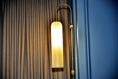 Otel odasının iç tarafındaki duvarda lamba var.