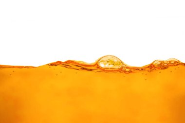 Beyaz zemin üzerinde kabarcık ve su sıçraması olan yakın turuncu su yüzeyi