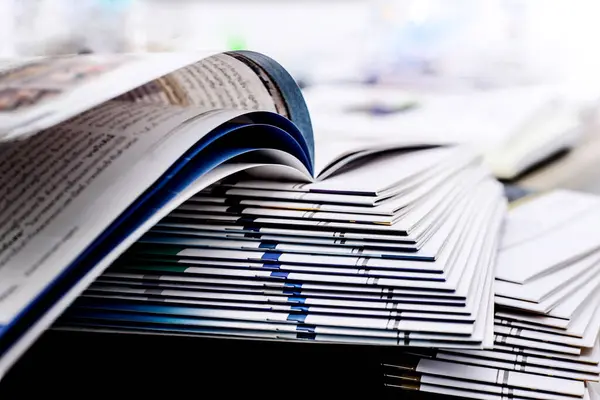 Açık kitap ve dergi yığınları belirli bir noktaya odaklanır Beyaz bir arkaplan, izole edilmiş