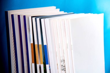 Mavi duvar arkaplanındaki kitap yığınını kapat.