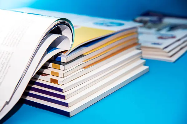 Mavi arkaplan üzerine açık kitap yığını, yakın plan, seçici odak