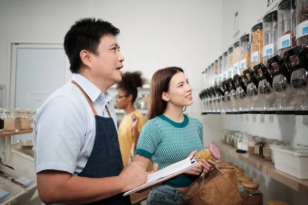 Aziatische Mannelijke Winkelier Beschrijft Natuurlijke Biologische Producten Voor Vrouw Klant — Stockfoto