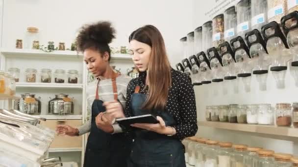 Två Unga Kvinnliga Butiksägare Arbetar Påfyllningsbutik Kontrollerar Lager Ekologiska Produkter — Stockvideo