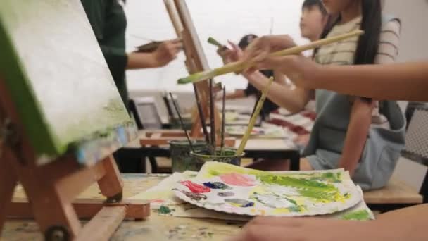 近距离拍摄丙烯酸色调色板 在美术课上与一群学生一起在画布上画画 在小学演播室教育中创造性地学习天赋和技巧 — 图库视频影像