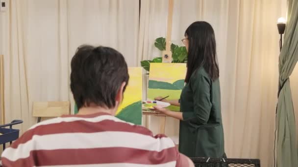 亚洲女教师在艺术课的画布上向学生展示丙烯酸彩绘 在小学演播室教育中创造性地学习技巧 — 图库视频影像